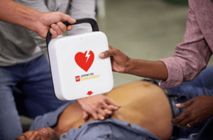 An AED in use while CPR is administered